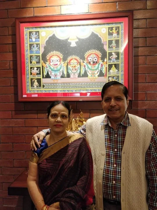 Pradeep Biswal and a woman standing beneath a framed Jagannath artwork