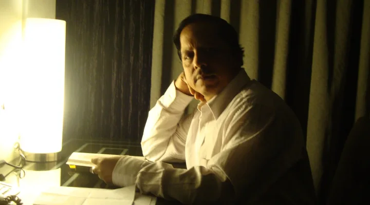 Pradeep Biswal seated beside a lamp